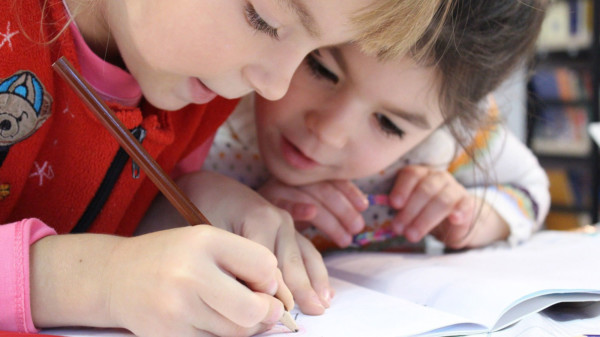 Das Bild zeigt zwei Kinder beim Lernen